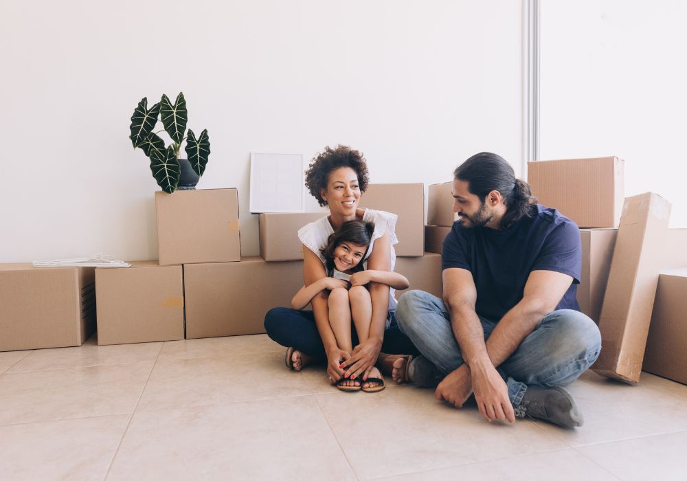 Family packing winter coats into boxes for a move to Canada